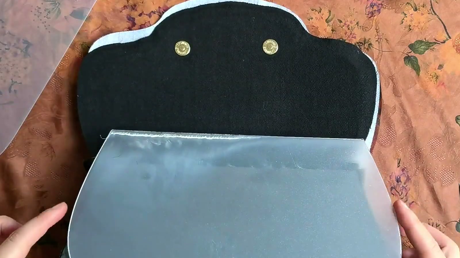 A translucent support board is flexed slightly and guided between the outer fabric and lining through the bag opening