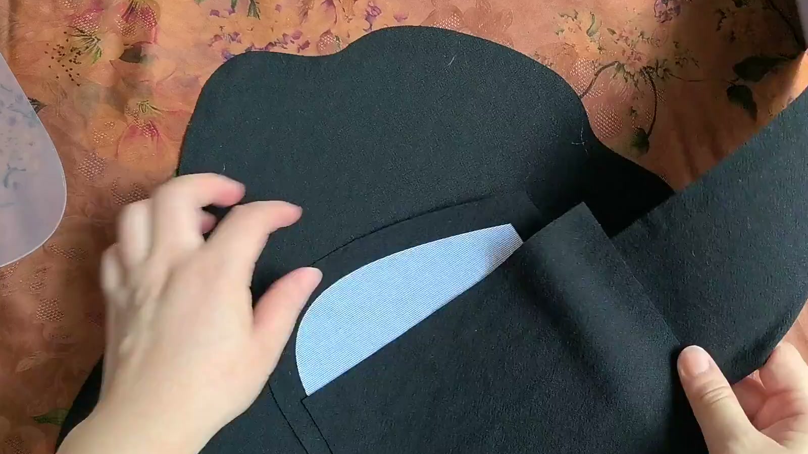 A hand holds a thinner black lining piece backed with fine stiff interfacing
