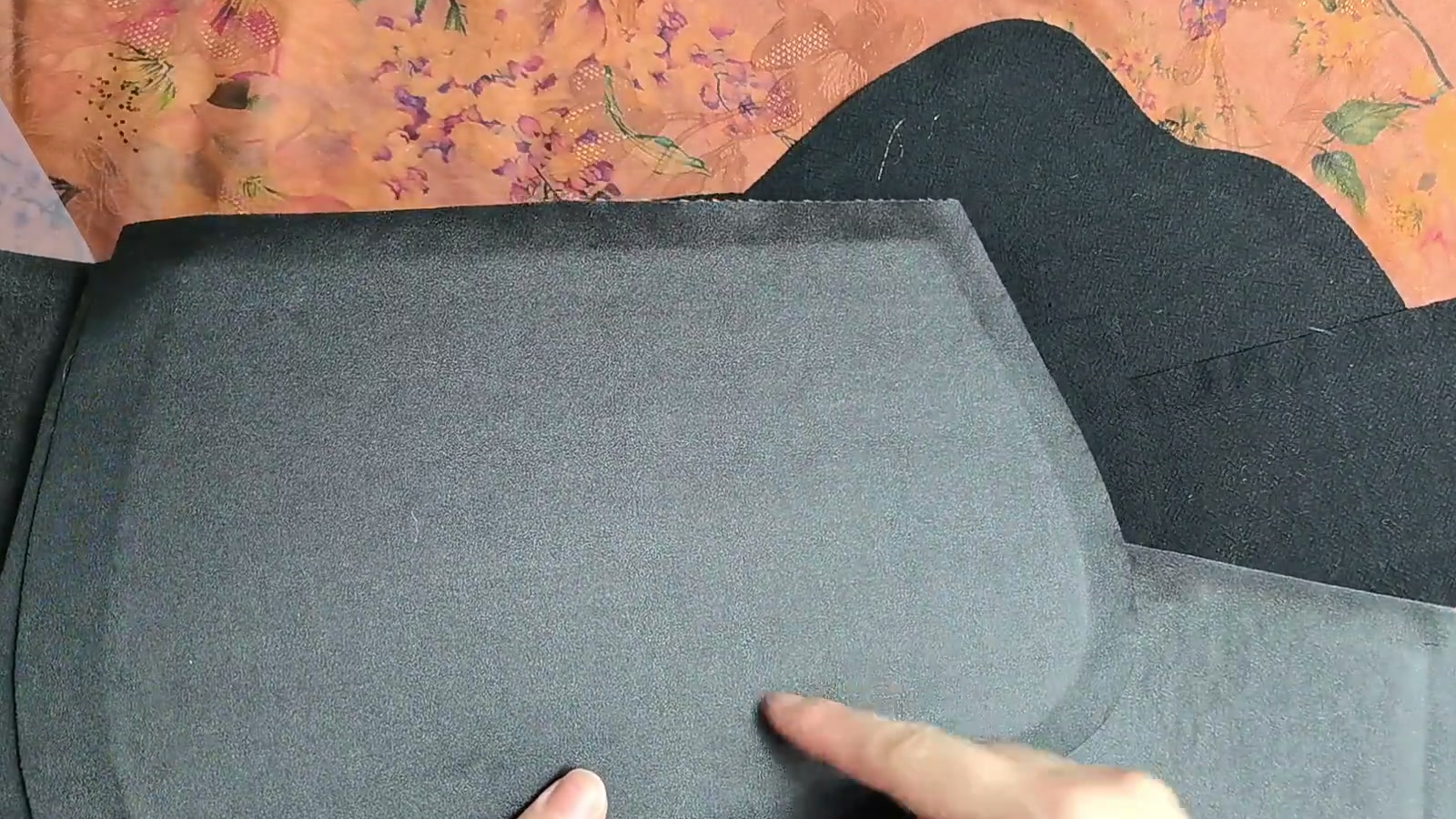 A hand displays a thicker outer-fabric piece backed with white batting