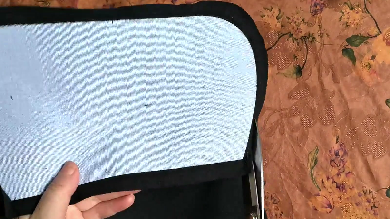 Scissors trim an overly wide black lining seam allowance while leaving the stitched seam intact